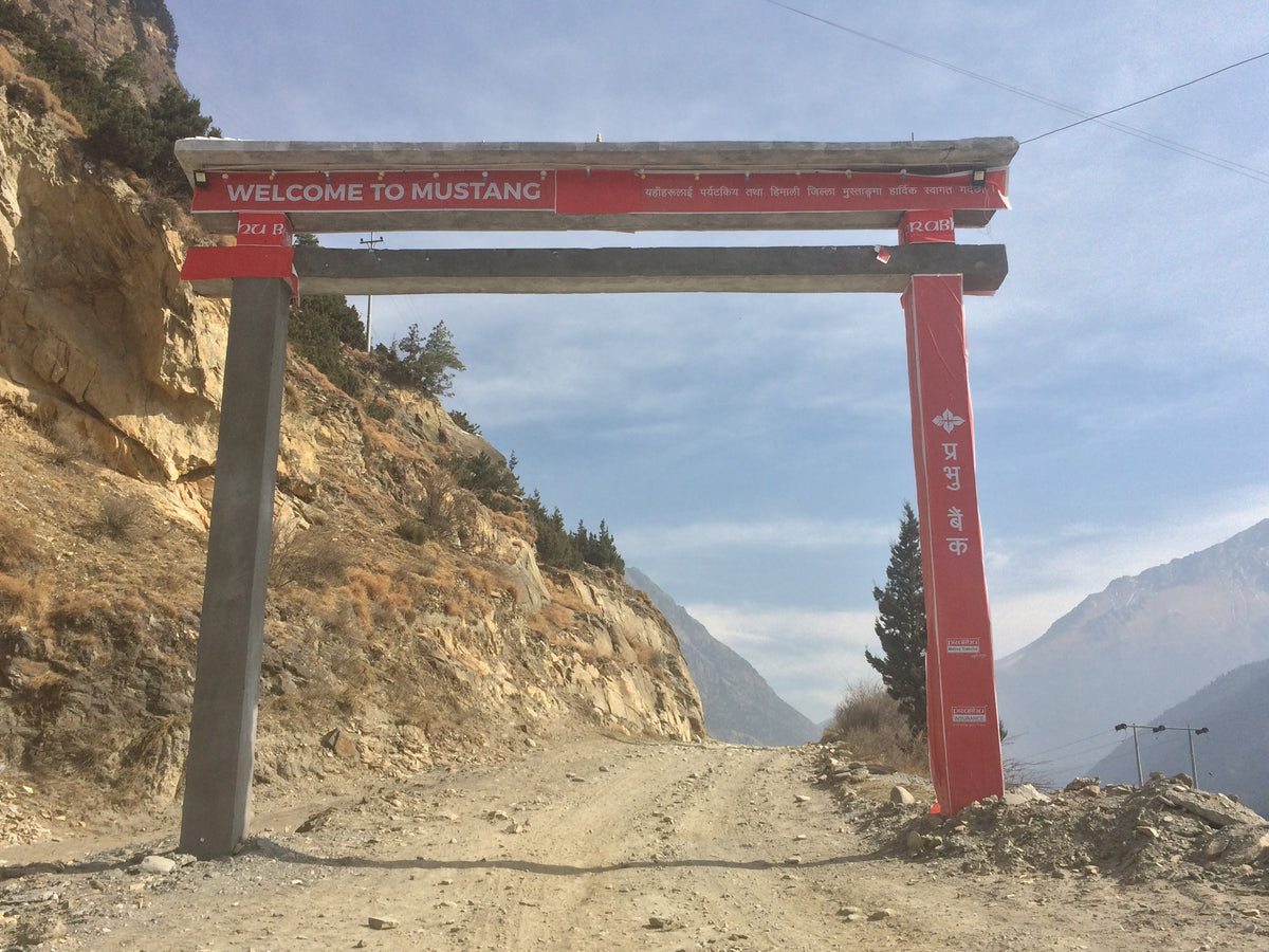 WELCOME TO MUSTANG gateway on an unpaved road (historical photograph)